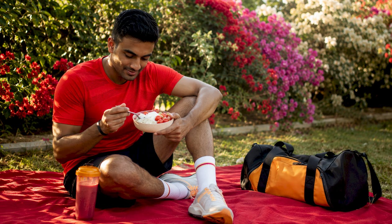Athlete eating post-workout protein snack outdoors