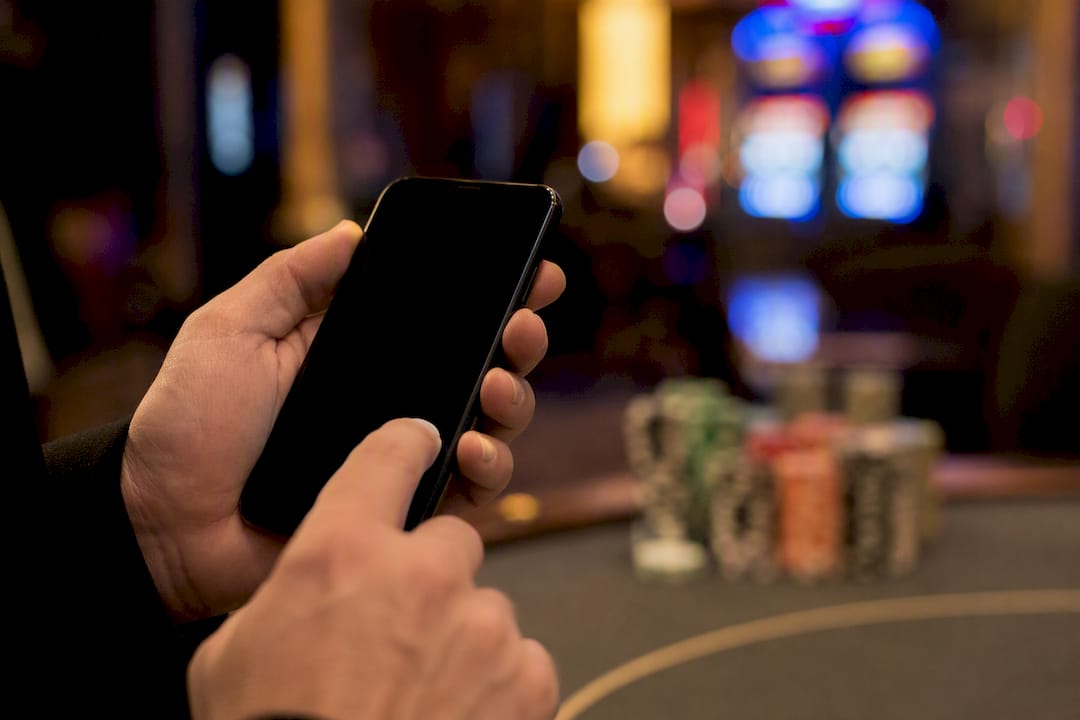 Kéz, amely SMS fizetést küld okostelefonnal kaszinóban