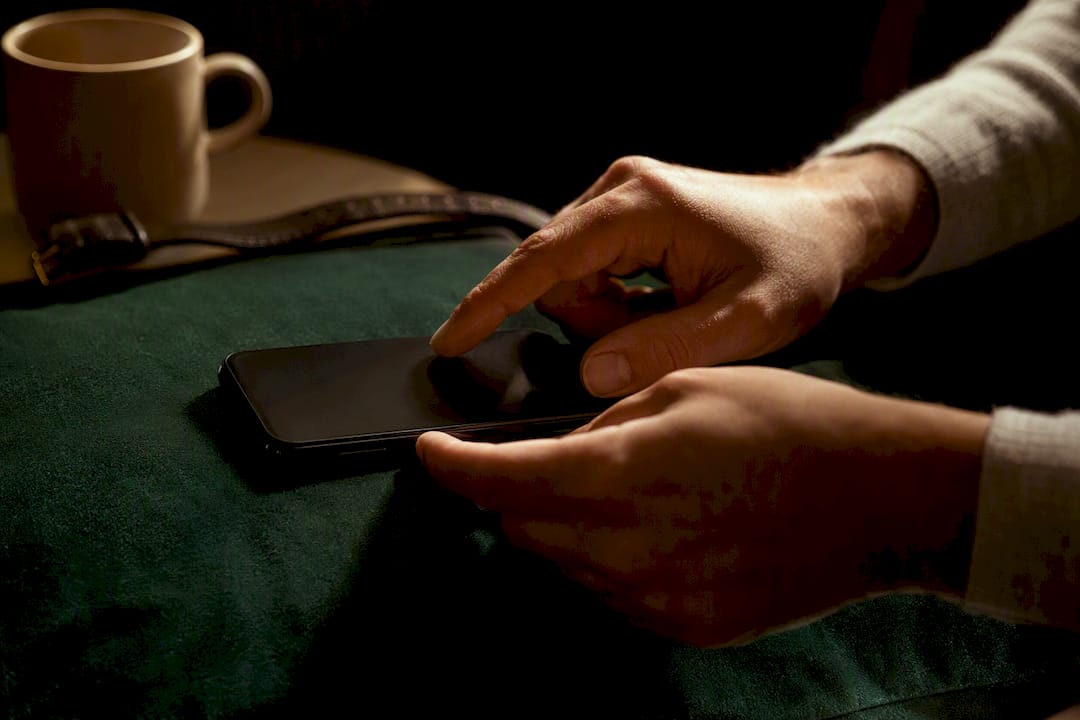 Kéz, amely időkorlátot állít be egy sötét telefonon