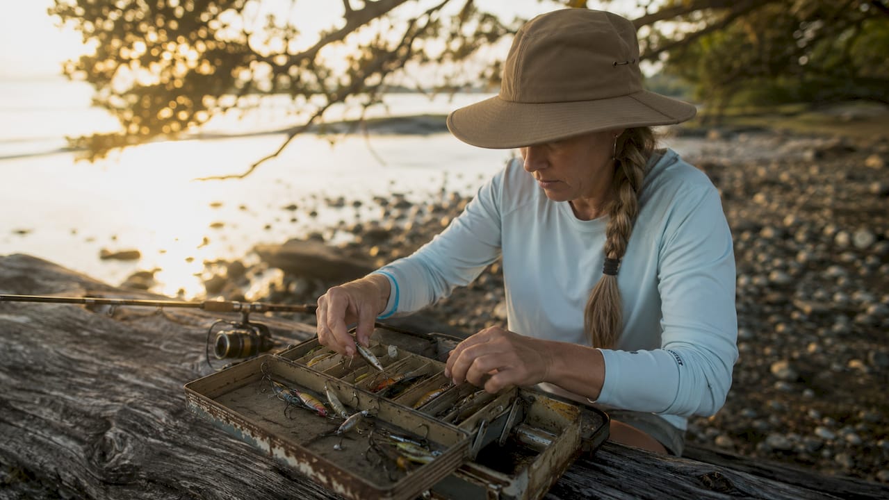Woman angler preparing tackle near oyster bar