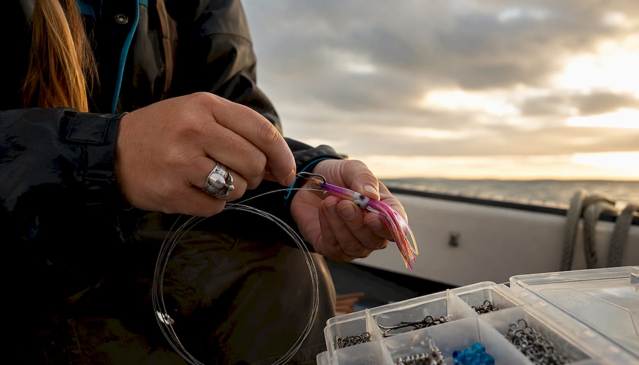 Hands rigging squid skirt fishing lure