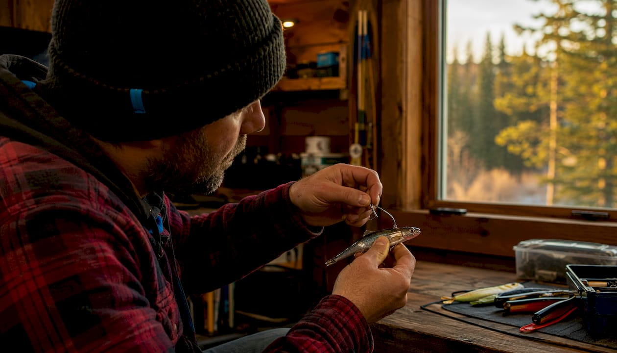 Hands tuning salmon teaser roll on dock