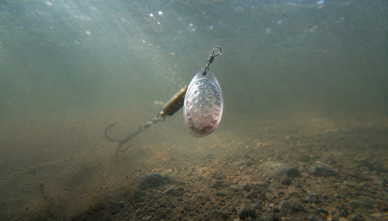 Spinner lure blade spinning under river water