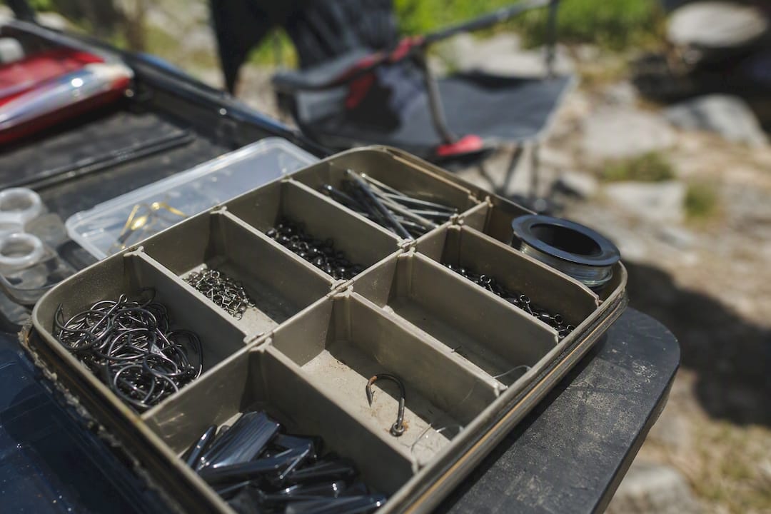Organized tackle box compartments showing early rust on hook