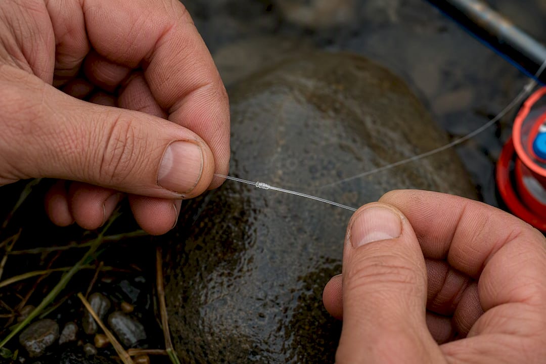 Hands checking an abraded leader knot