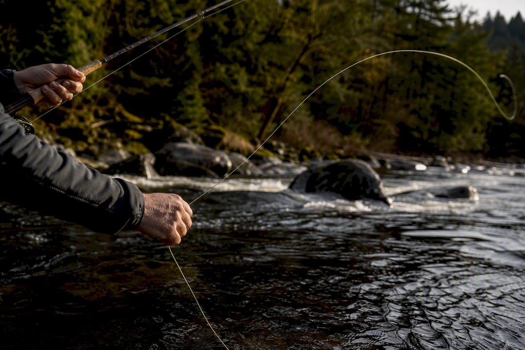 Angler mending line over river current