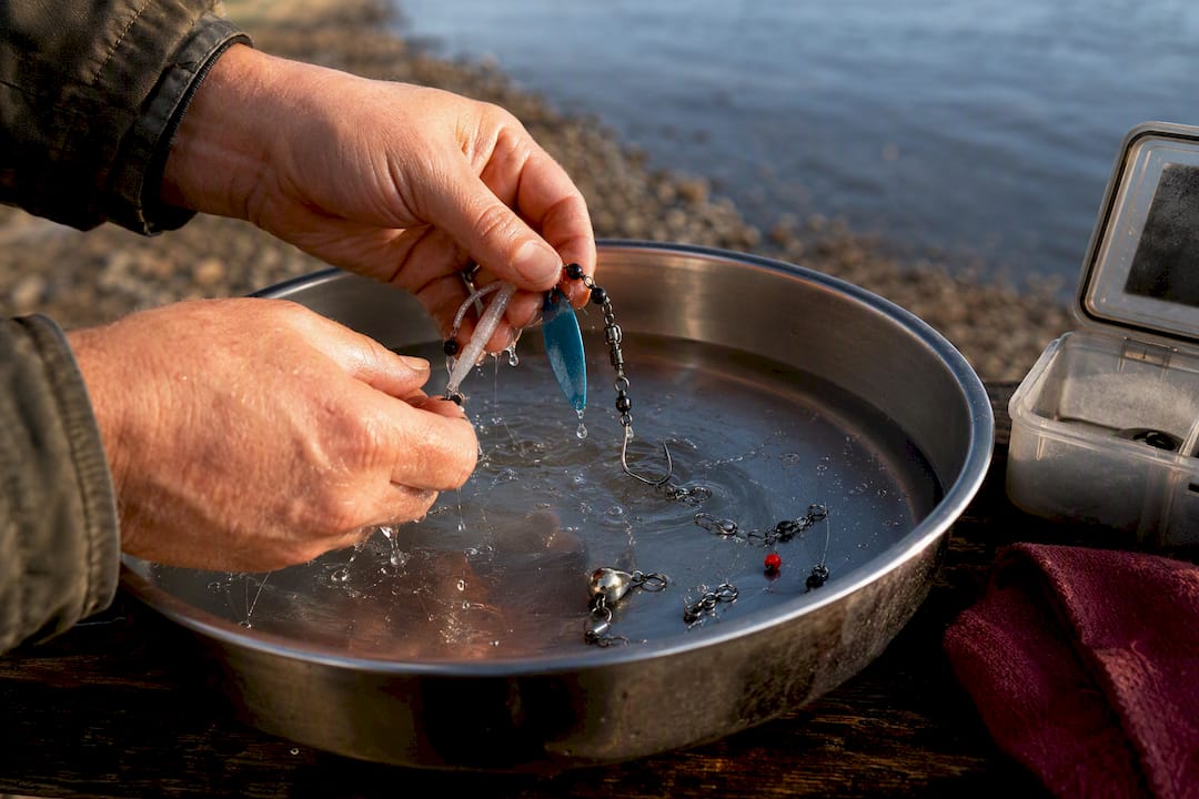Hands rinsing salmon fishing terminal tackle