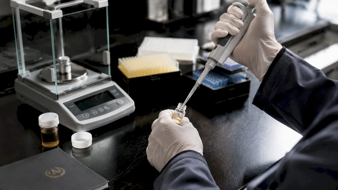 Hands pipetting plasma sample in laboratory