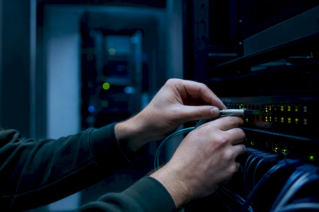 Hands managing data cable in AI data center