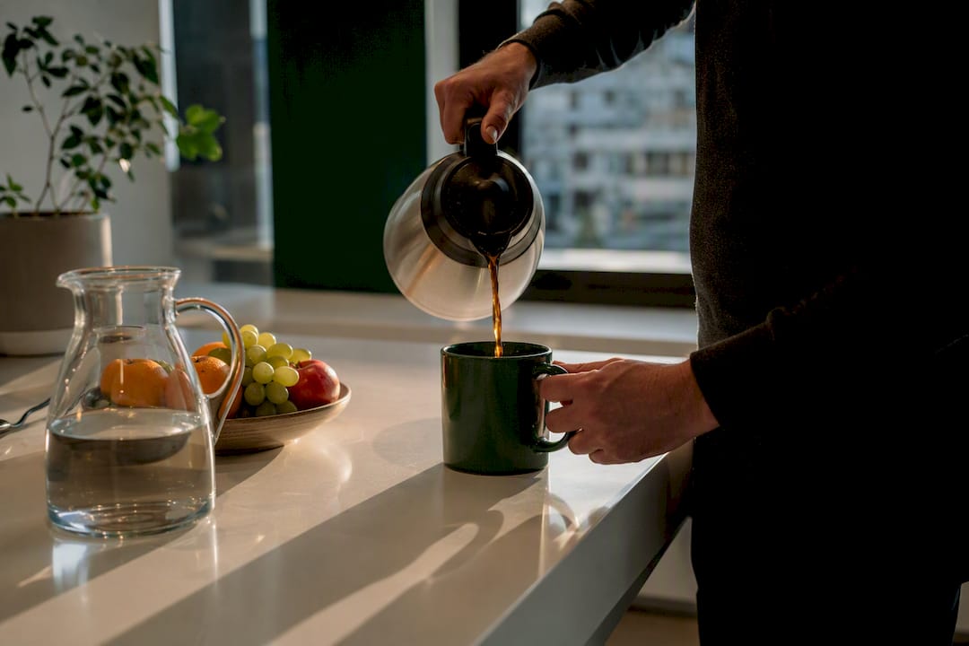 Person pouring coffee in office break area