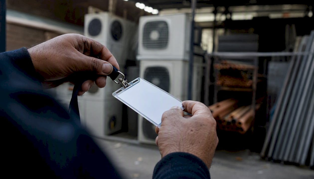 Hands holding apprentice badge in mechanical room
