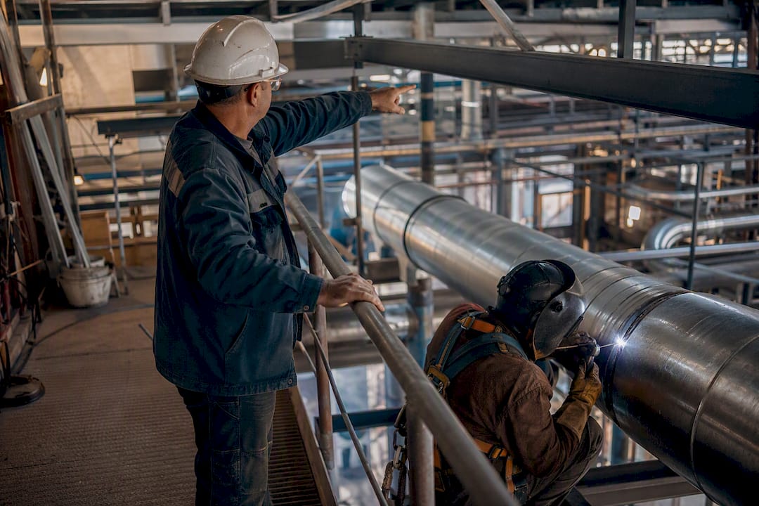 Foreman directing pipefitter during installation