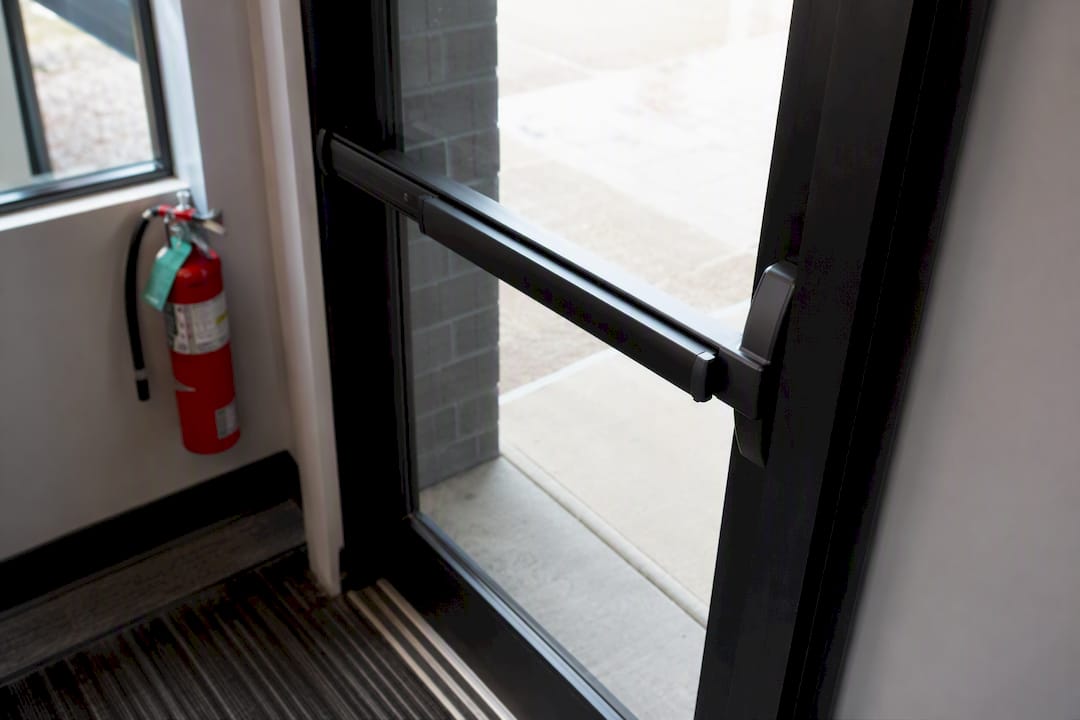 Close-up of commercial door with rim panic hardware