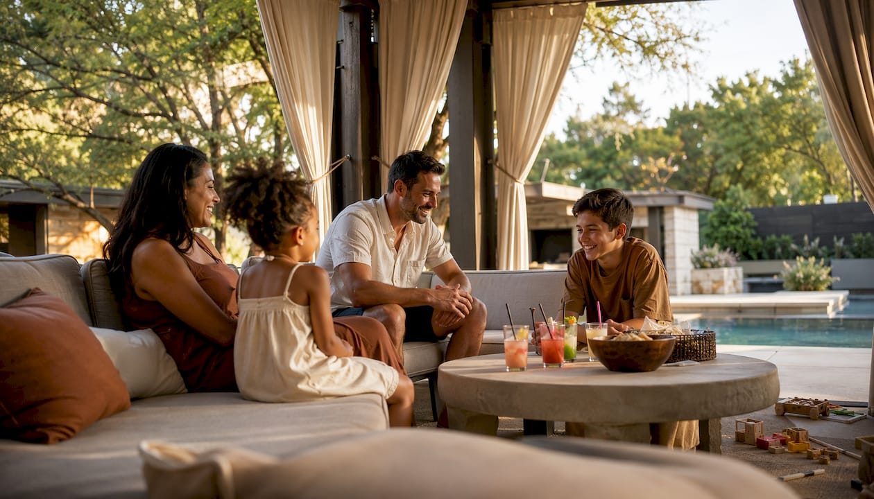 Family relaxing near pool cabana in backyard