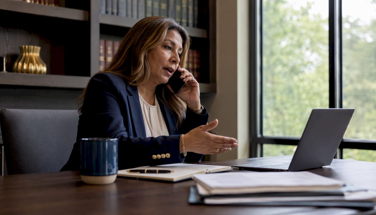 Woman reporting crypto scam on phone with notes
