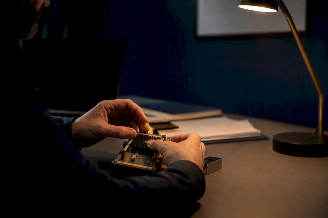 Hands assembling cryptographic token on desk