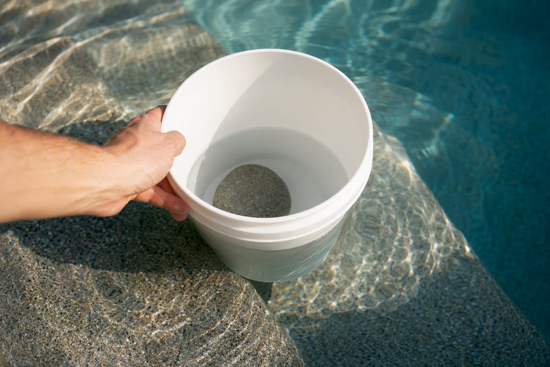 Homeowner setting up a pool bucket test