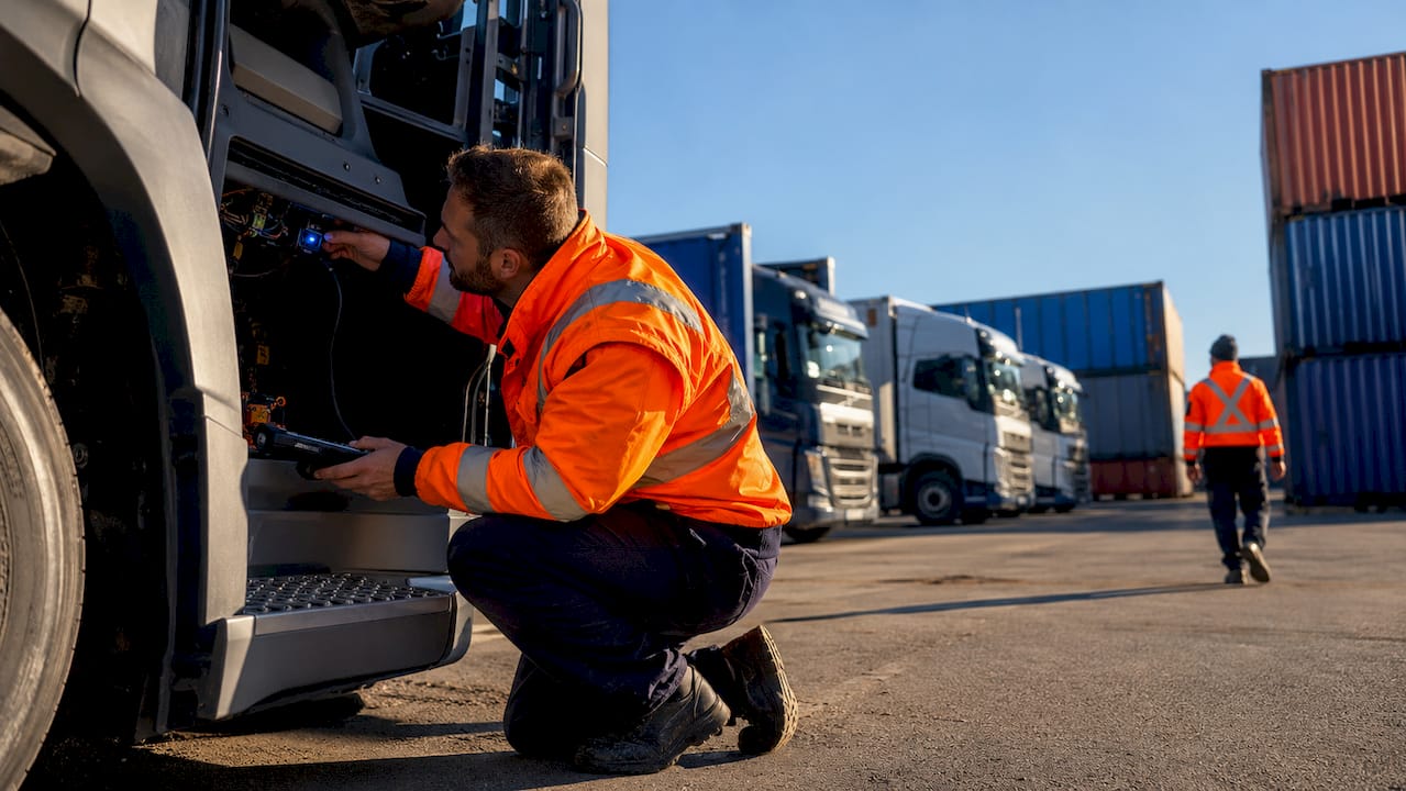 Technician inspecting telematics on heavy goods vehicle