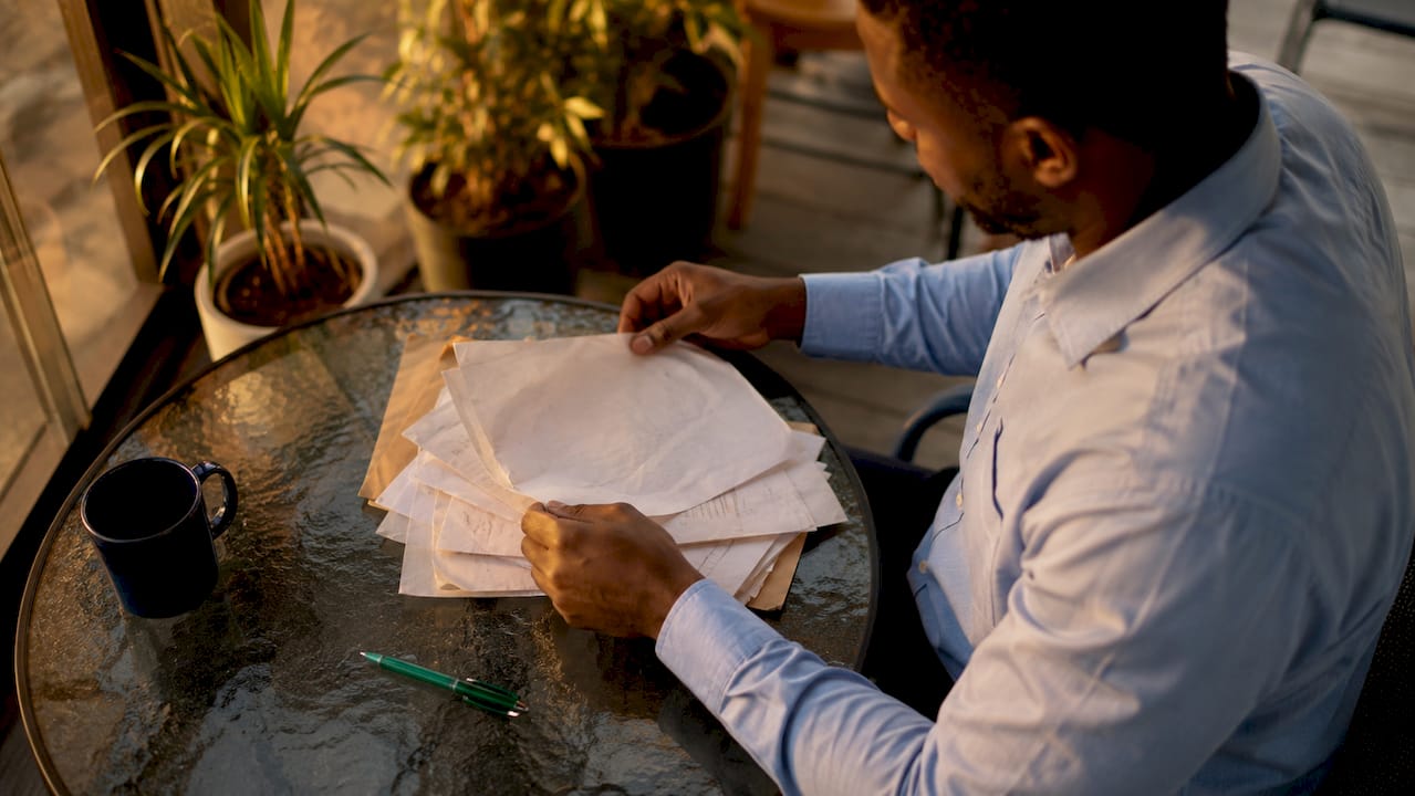 Manos ordenando documentos de envío sobre una mesa