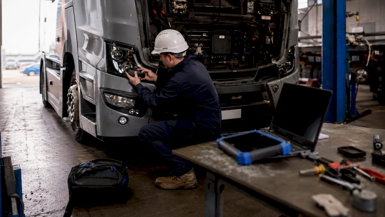 Technician installing telematics device in HGV