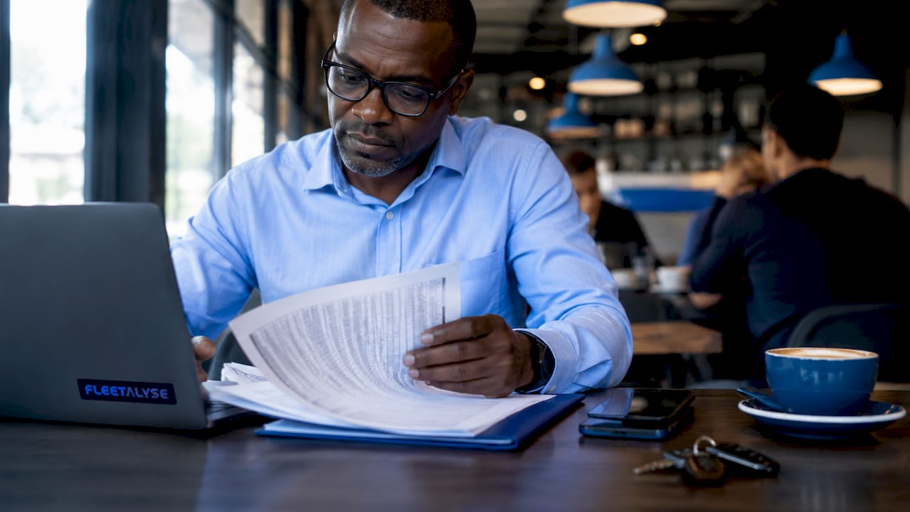 Man reviewing mixed fleet maintenance logs at desk