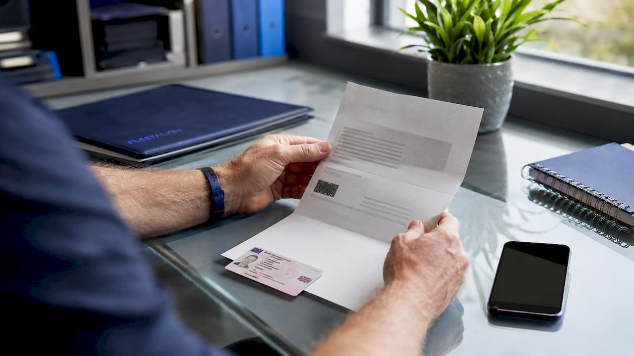 Hands holding licence and share code documents
