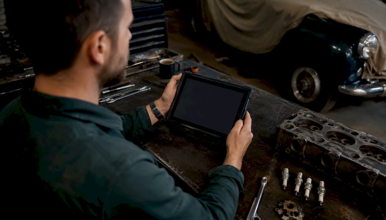 Mechanic using diagnostic tablet in workshop