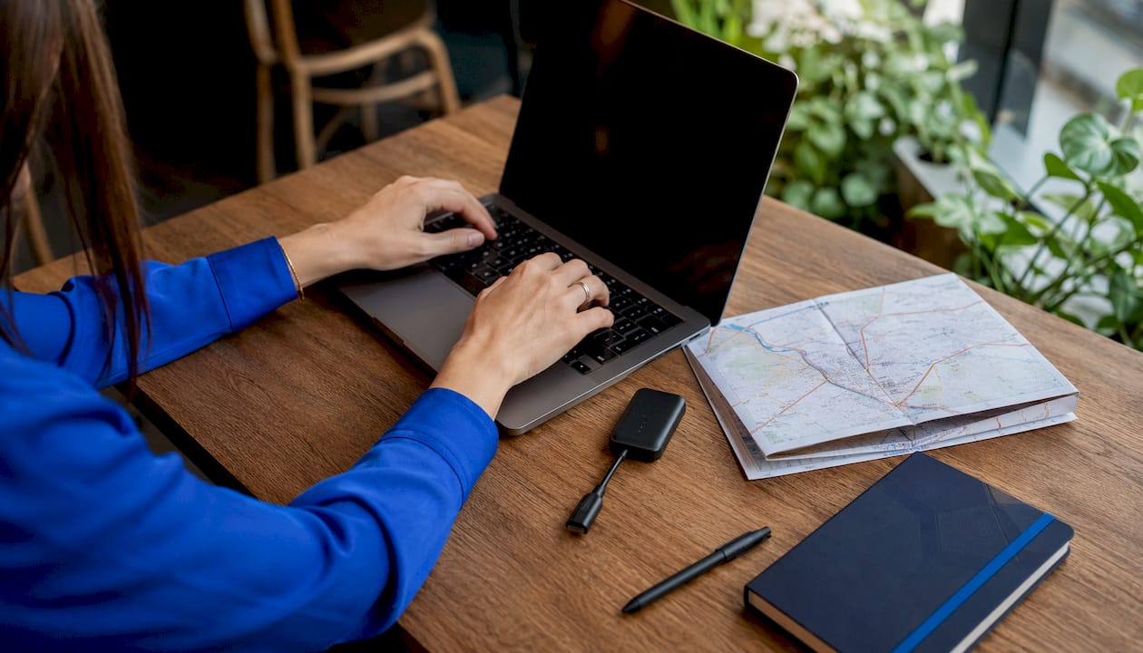 Logistics coordinator typing with GPS device on desk