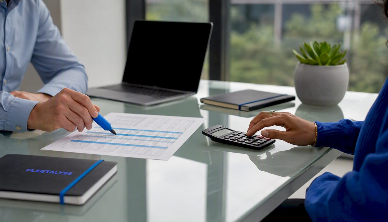 Hands pointing at vehicle tracking budget table