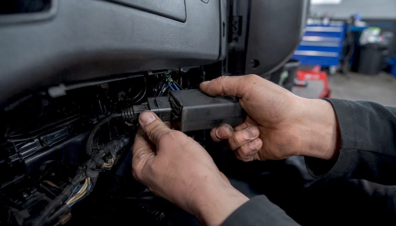 Hands connecting telematics device for tachograph download