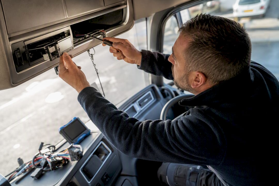 Technician fitting smart tachograph unit