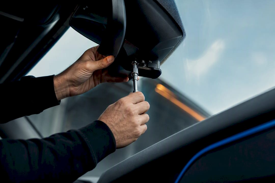 Dashcam mount being adjusted behind cab mirror