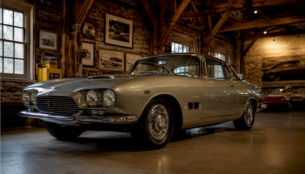Historic coupe-style carriage in vintage museum setting.