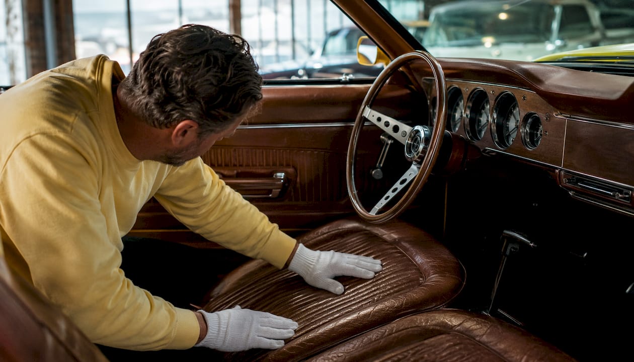 Hands examining classic car upholstery