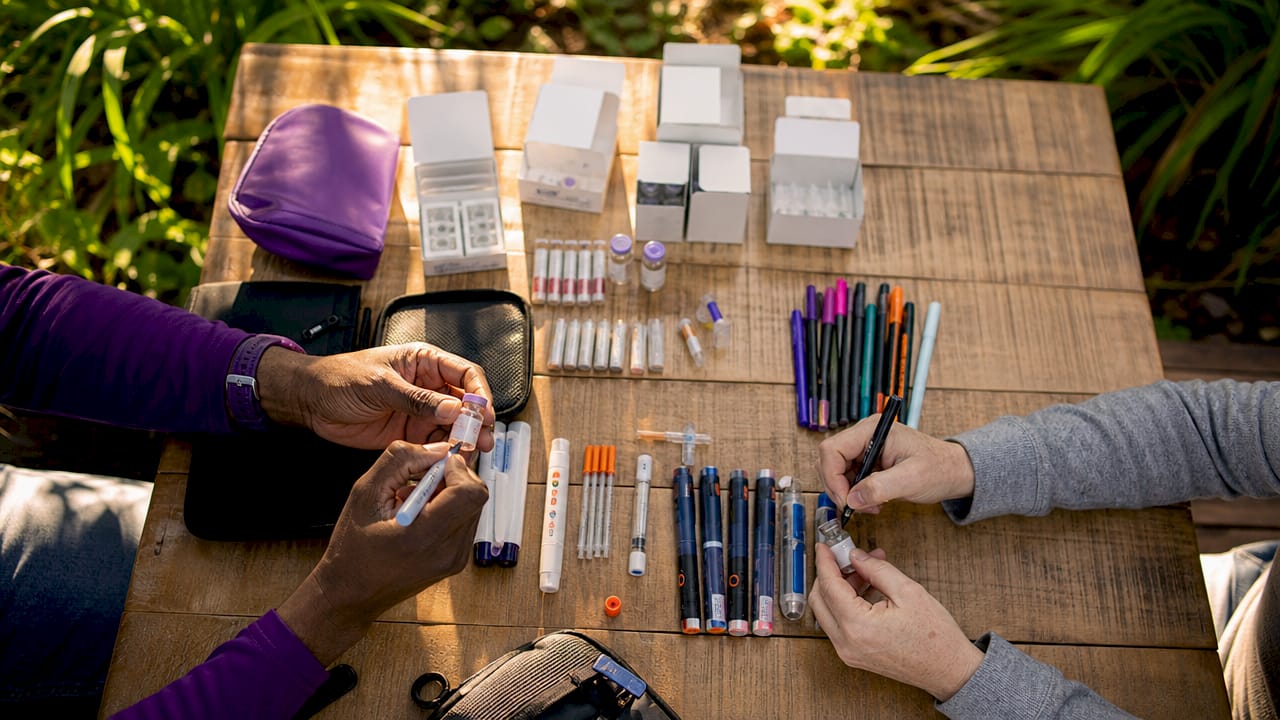Close-up hands labeling diabetes supplies