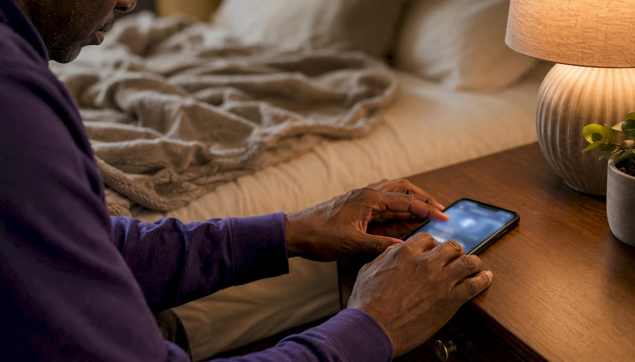Hands adjusting CGM alarm on phone