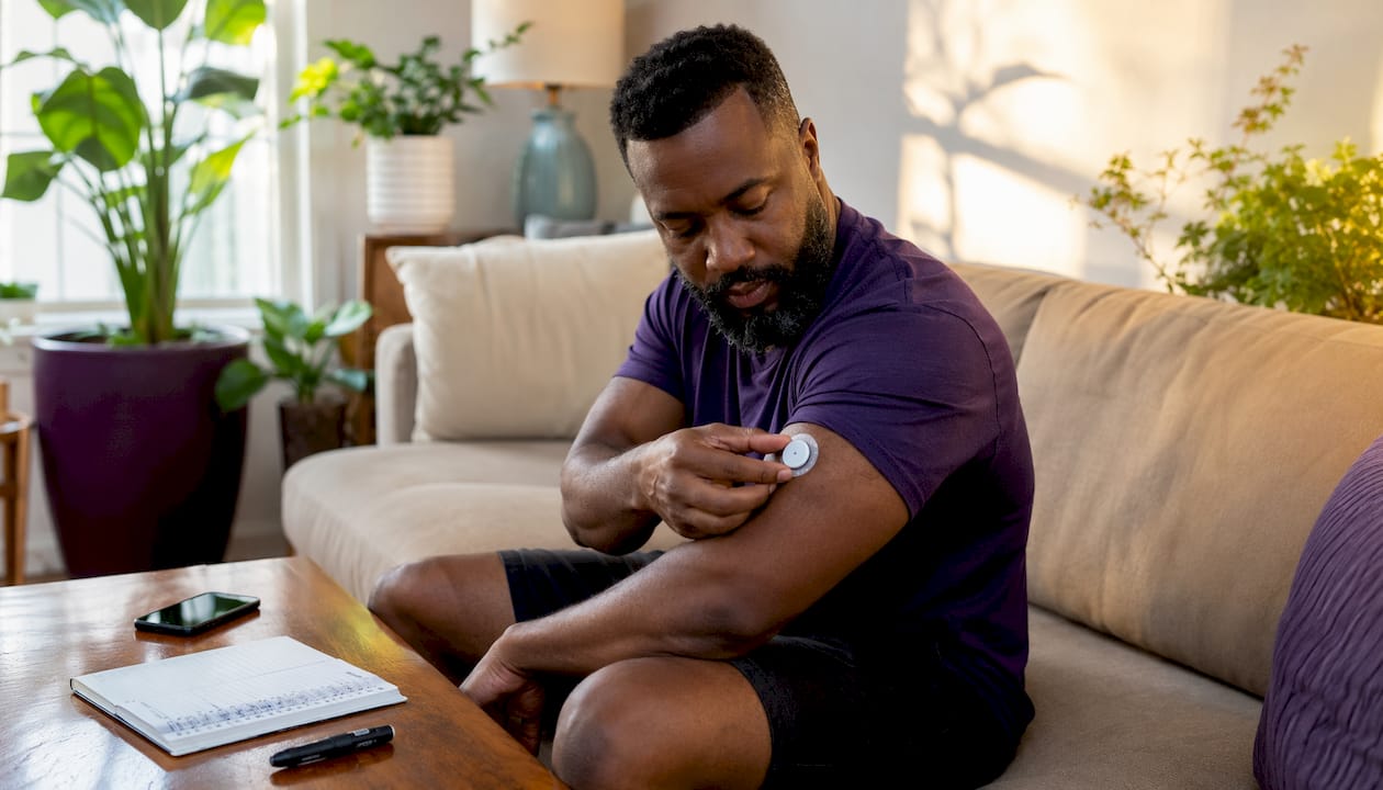 Hands applying glucose monitor sensor at home