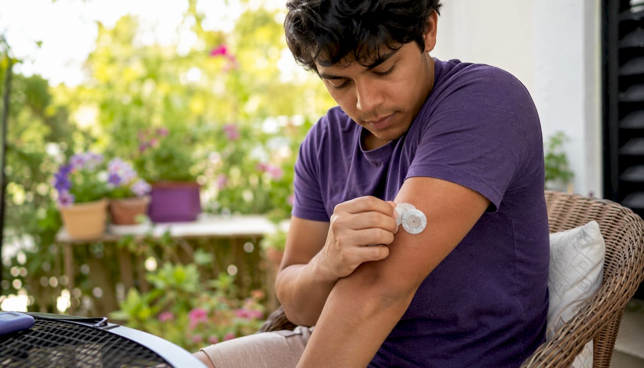 Close-up of hands removing CGM sensor