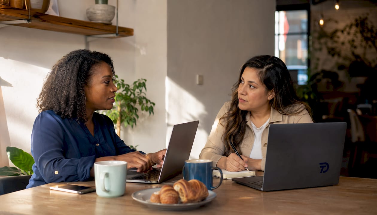 Two women comparing martial arts software options