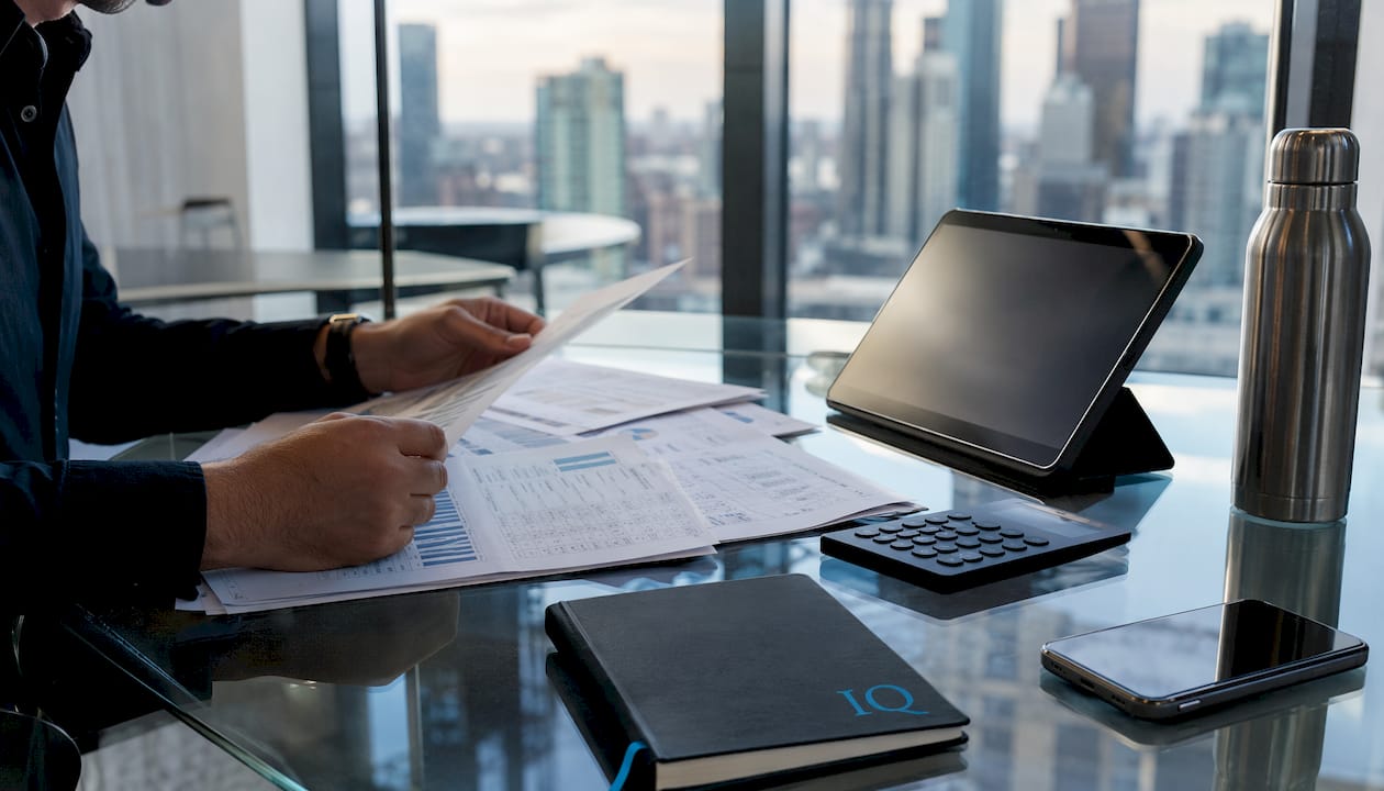 Hands working on financial planning documents and calculator