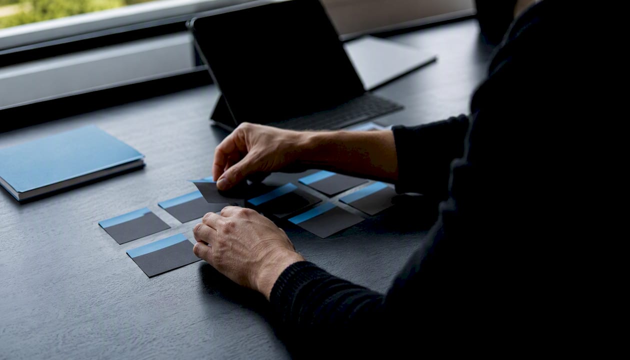 Hands updating digital roadmap cards on desk