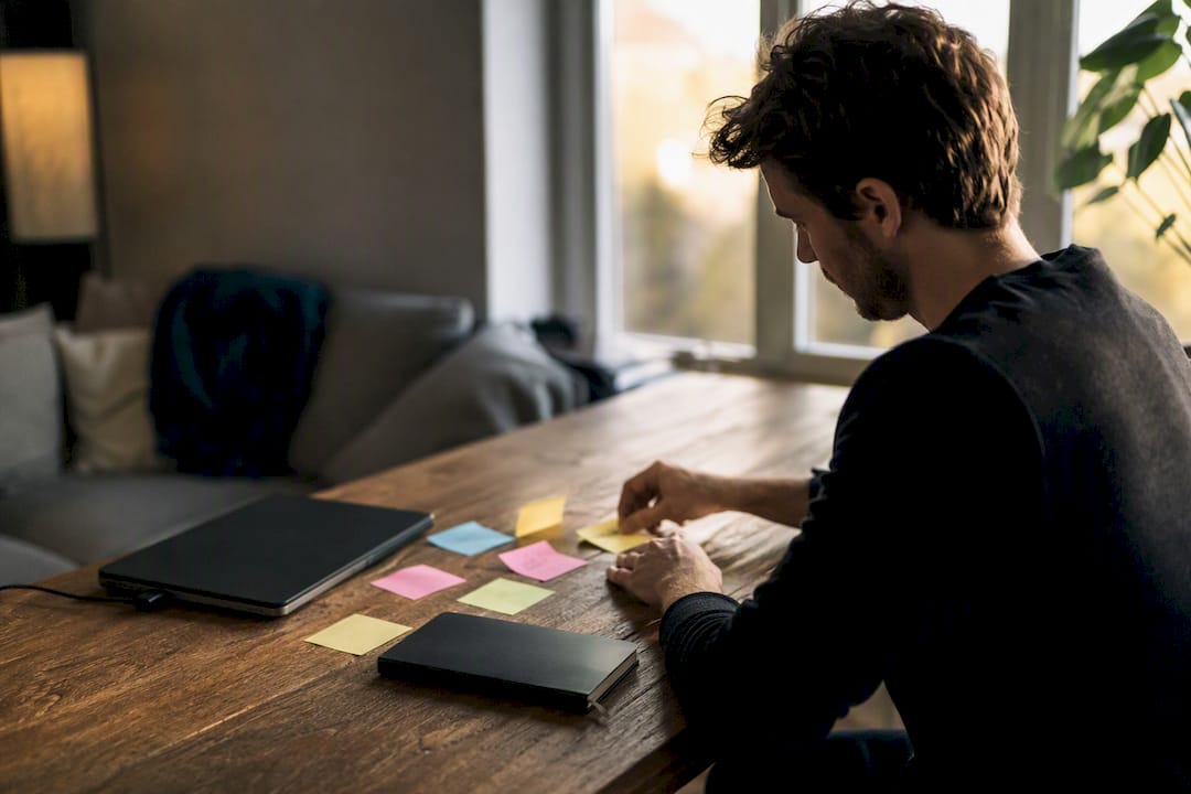 Founder's hands organizing planning tools on dark desk