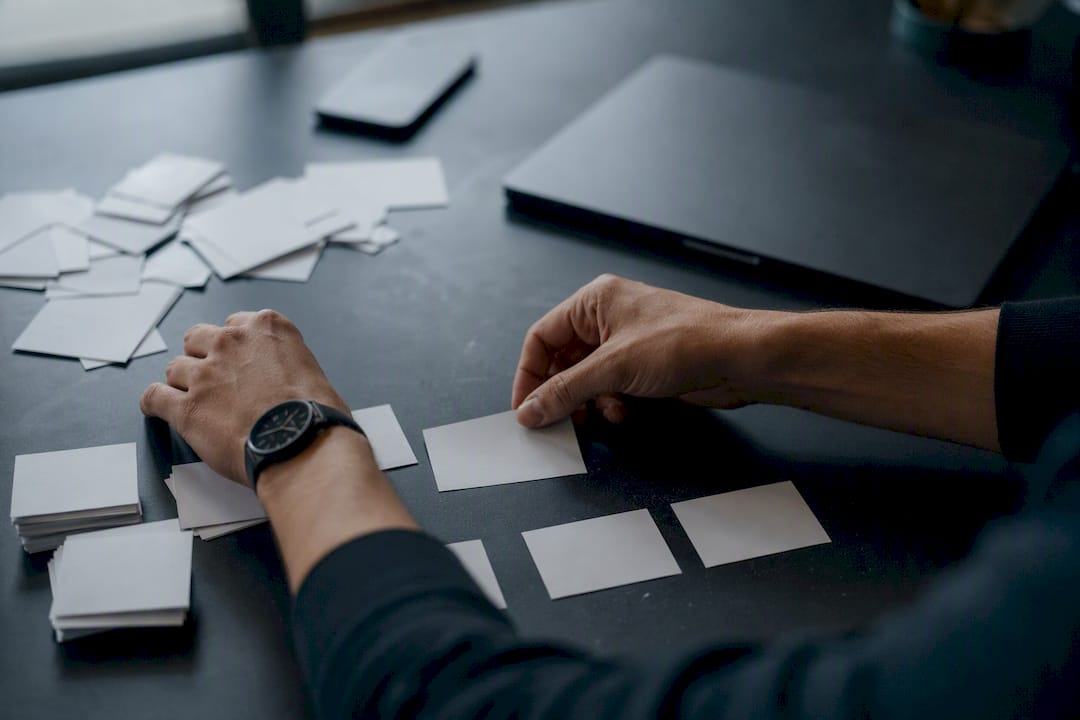 Hands simplifying agenda cards on desk