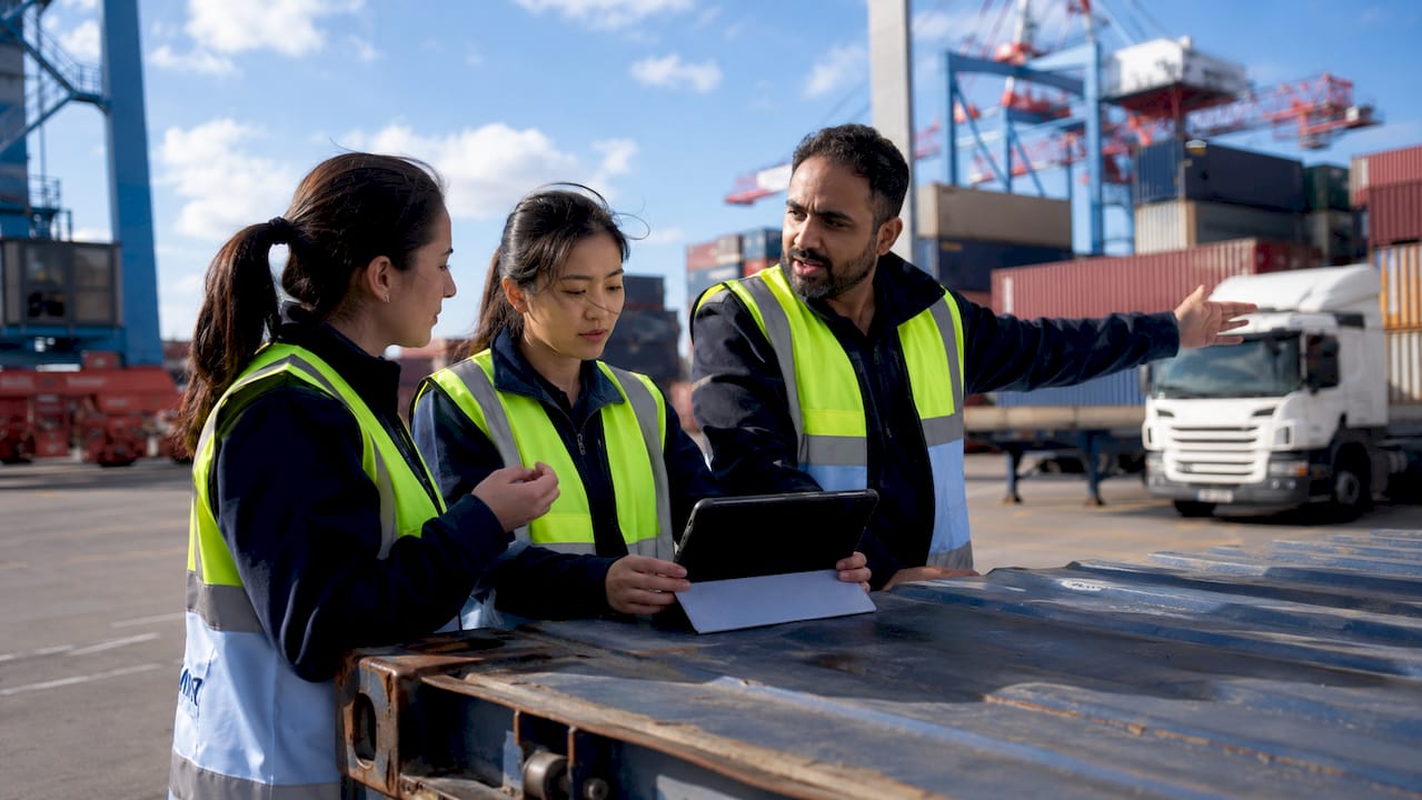 Diverse shipping team coordinating cargo operations outdoors