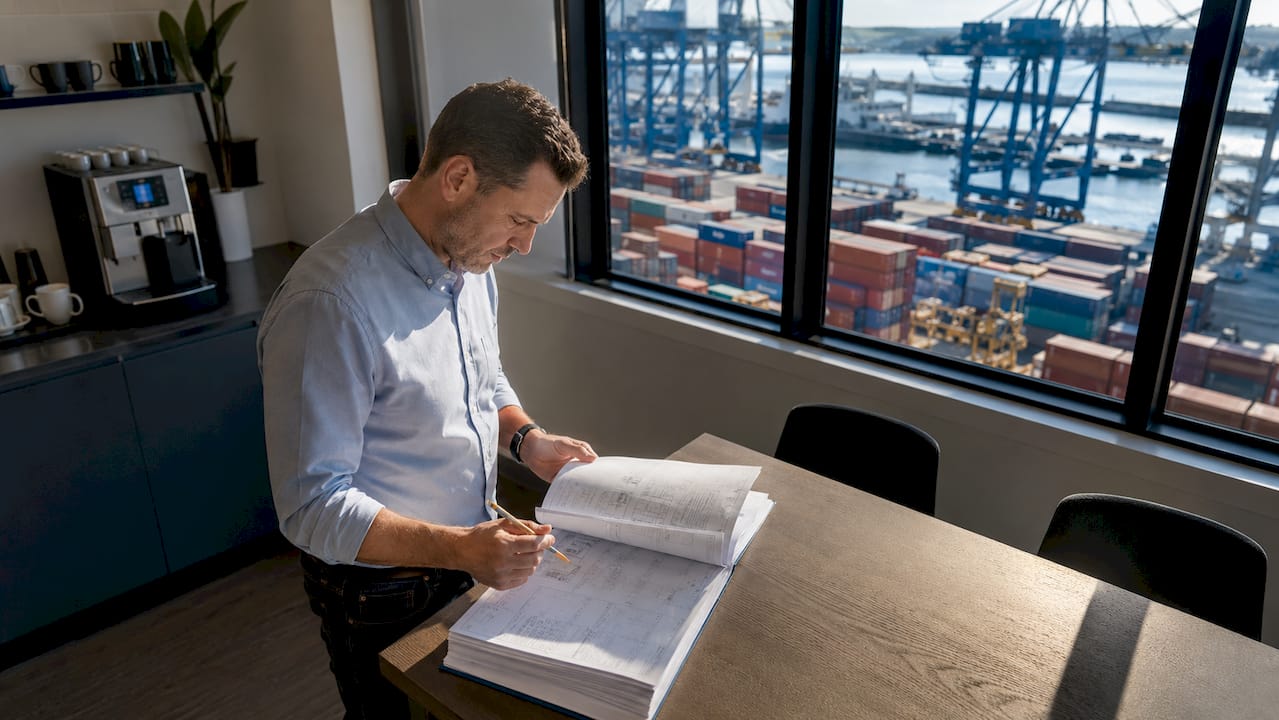 Logistics manager reviewing ISO container manual in office