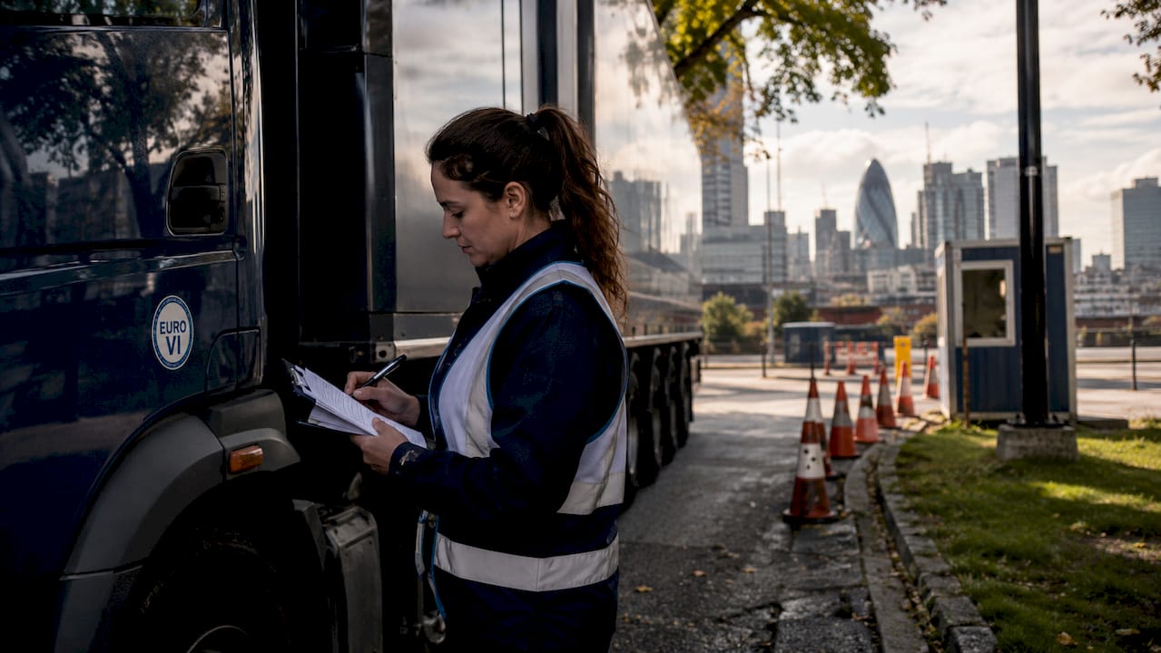 Female officer inspecting HGV safety permit roadside