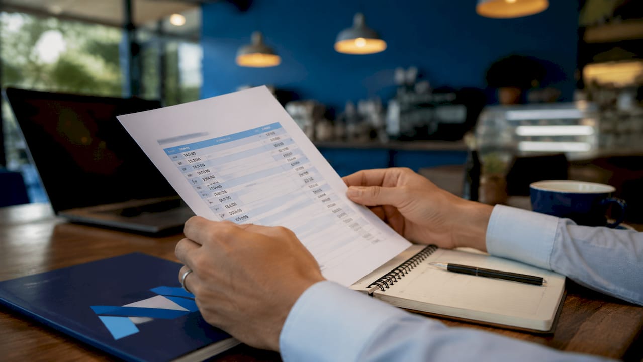 Hands holding tablet with logistics materials on desk