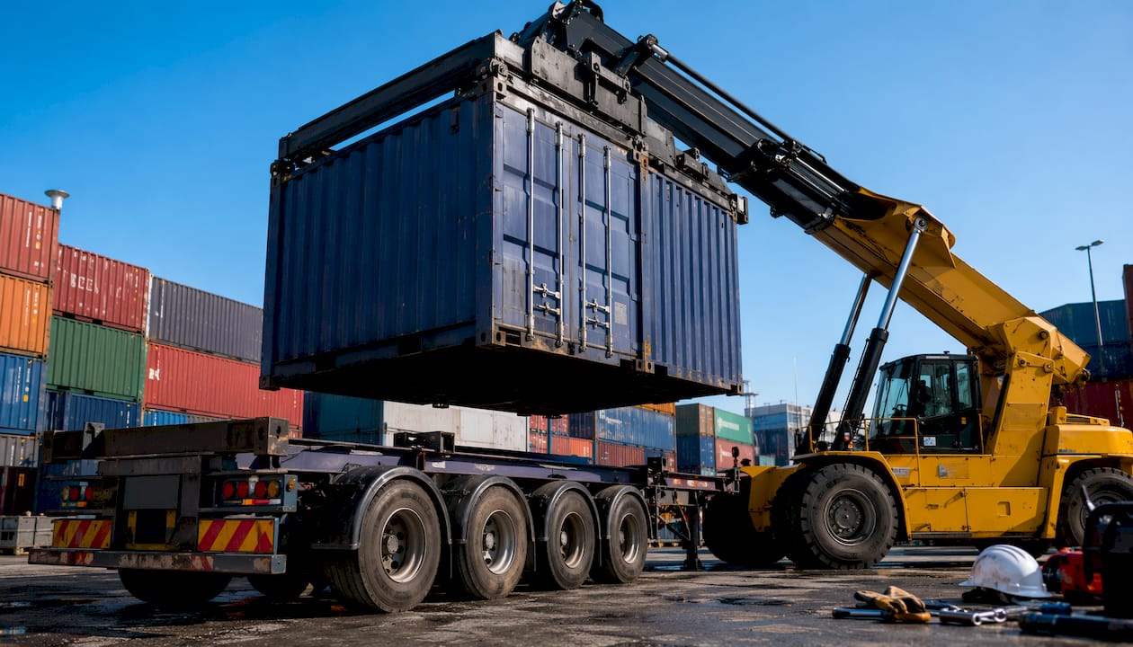 Skeletal trailer being loaded with container by crane
