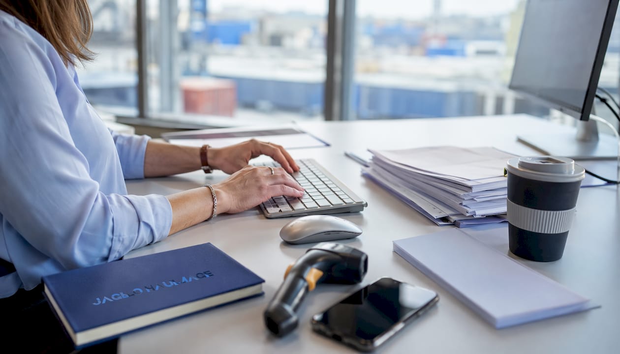 Hands typing on keyboard with haulage tools