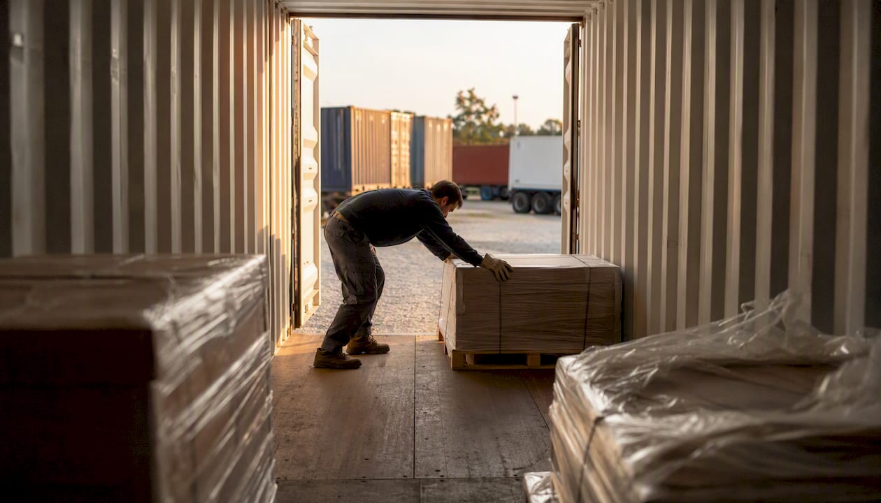 Worker positioning freight load inside trailer
